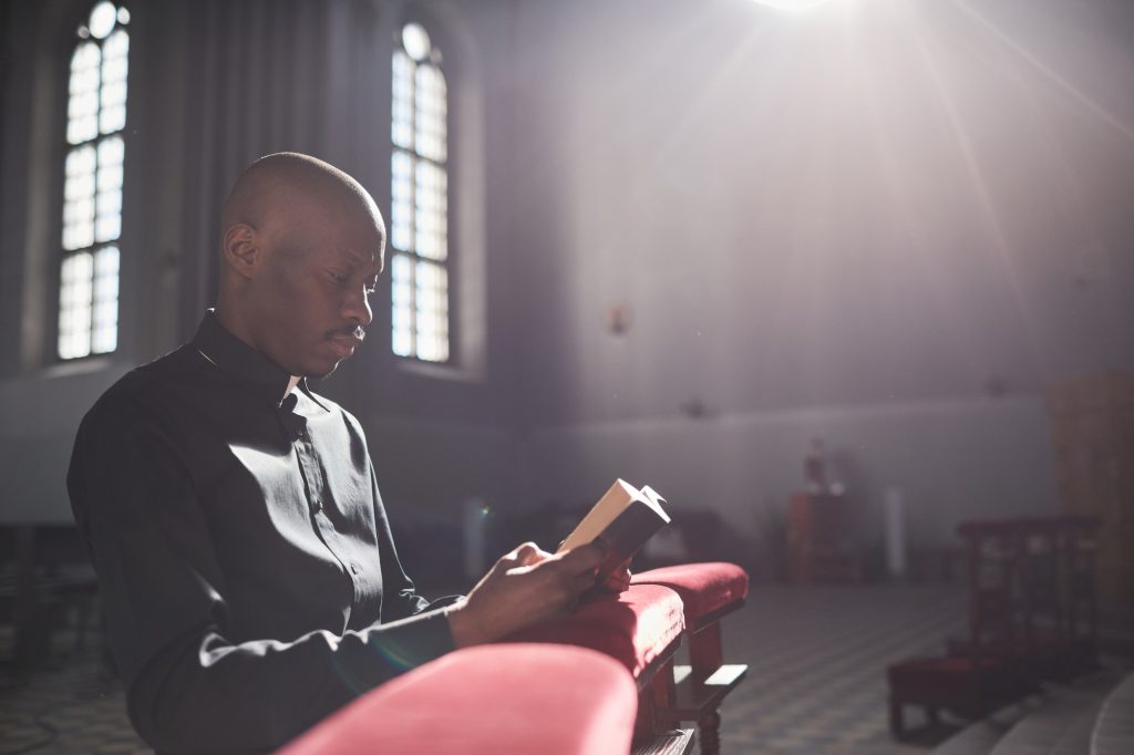 Priest praying with Bible